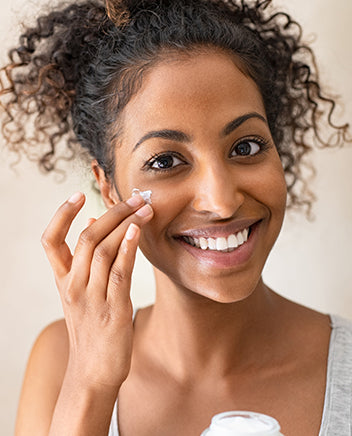 a woman applies skin cream after getting her perfect skin quiz results